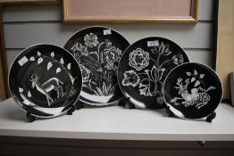 Four handpainted monochrome plates, signed D Bates