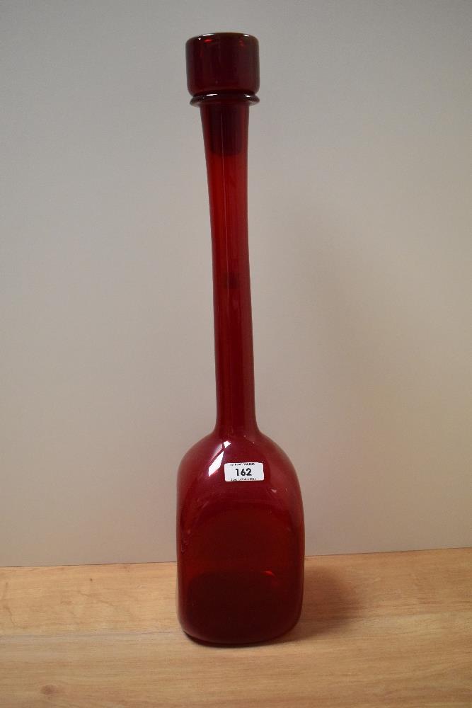 An Italian ruby glass decanter with elongated neck and dimpled body of square form.