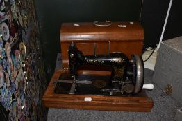 An antique Vesta crank handled sewing machine with bentwood case, serial number 1763409.