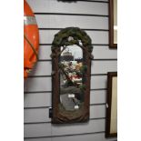 A ceramic framed wall mirror with frame in the style of a forest.