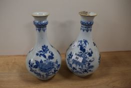 A pair of 19th Century blue and white bottle vases, chips to rim