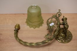 A vintage brass adjustable wall light and glass shade