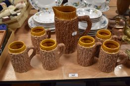 A mid century jug and set of mugs, in the form of tree trunks.