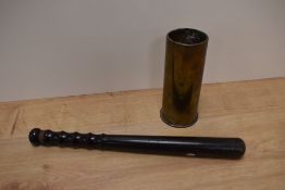 A vintage truncheon and brass mortar shell