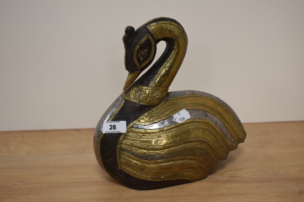 A middle eastern wooden swan, brass clad with embossed details.