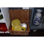 A vintage wicker picnic basket including Melaware plates, assorted cutlery etc
