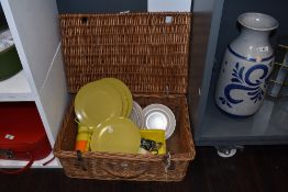 A vintage wicker picnic basket including Melaware plates, assorted cutlery etc