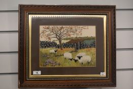 A framed and glaze20d country scene embroidery with sheep.