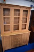 A modern beech laminate bookcase/display cabinet with cupboard base