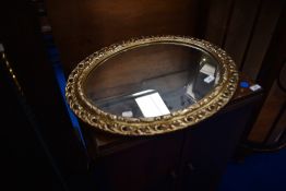 A gilt frame oval wall mirror