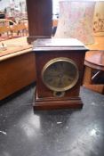 An oak cased mantel clock with brass roman numeral dial