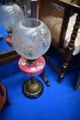 A Victorian oil lamp having decorative glass reservoir on brass base