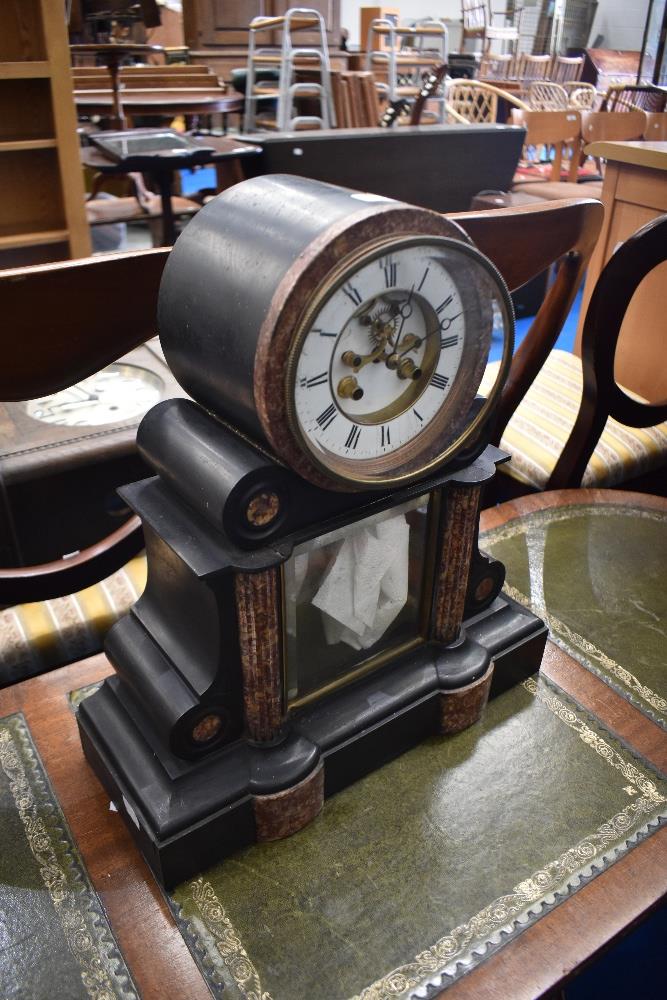 A Victorian black slate and rouge marble mantle clock having enamelled roman numeral dial