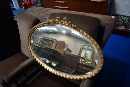 An oval wall mirror having bow decoration