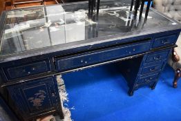 An Oriental laquerwork desk with soapstone relief under glass top