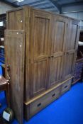 A modern solid wood triple wardrobe having drawer base