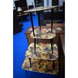 A kitsch vintage nest of four table with floral design and dansette style legs