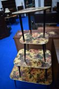 A kitsch vintage nest of four table with floral design and dansette style legs