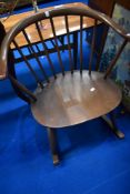 A vintage Ercol dark stained rocker having cow horn style spindle back