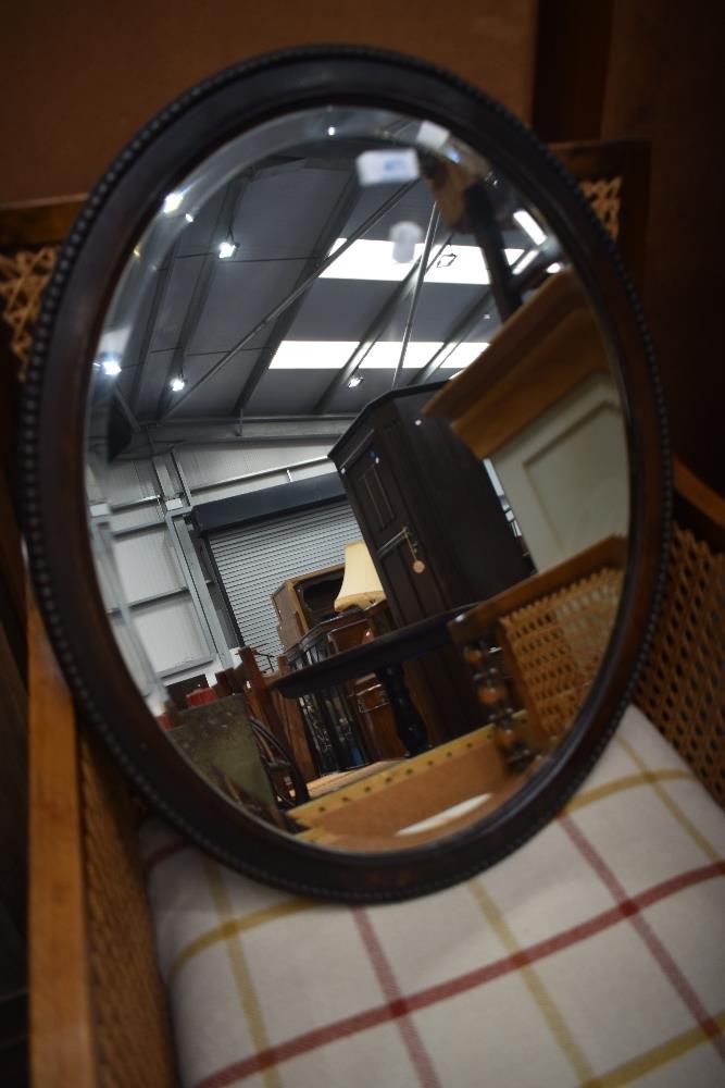 An early 20th Century oak oval wall mirror