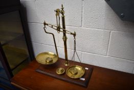 A Victorian brass balance scale on mahogany base , stamped Avery and Agate Patent, with selection of
