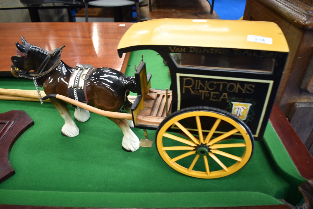 An ornamental ceramic heavy horse with Ringtons tea branded cart behind