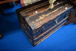 A vintage dome top travel trunk
