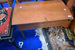 A vintage teak sewing table