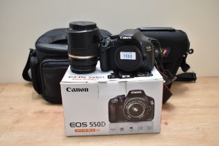 A Canon EOS550D digital camera with Tamron 18-270mm 1:3,5-6,3 lens. Boxed with charger in soft