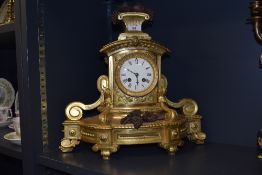A 19th century ormolu clock, having grape decoration to foot and finial and enamel face with Roman
