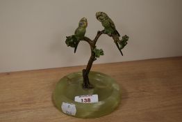 An Art Deco cold painted pin dish/ ash tray, adorned with two parrots, sat aloft an onyx base.