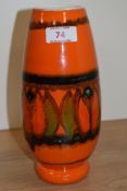 A mid century Poole Pottery vase, having orange ground with green,red and black abstract pattern.