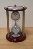 A mantel clock in the form of an egg timer.