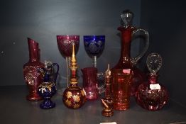 A collection of coloured glass, including Perfume bottles, blue jug with enamel decoration, decanter
