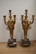 A pair of 20th century carryatid four branch candlesticks with green marble bases.