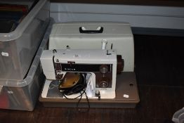 A vintage Singer electric sewing machine with instructions