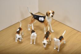 A group of four Beswick Pottery Fox Hounds, two with damages, and sold along with a larger John