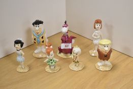 A complete group of seven John Beswick 'Flintstones' figures and figurines, comprising, Fred, Wilma,