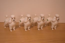 A group of four Beswick Pottery dog studies 'Poodle' number 2239, in white gloss, designed by Graham