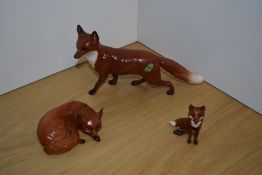 A group of three Beswick Pottery fox studies, Fox standing, 1016A in red/brown and white gloss,