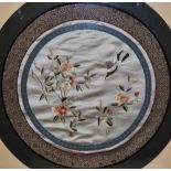 A 20th Century Chinese silk embroidery, of circular form, depicting a bird beside flowering branche