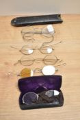A selection of antique spectacles and two hat pins.