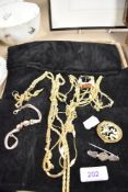 A jewellery case containing a selection of gold tone necklaces, an antique hallmarked silver