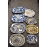 A selection of antique blue and white platters, also one in brown with pagoda scene.