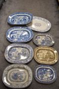 A selection of antique blue and white platters, also one in brown with pagoda scene.