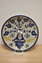 A vintage continental platter, having stone toned ground with blue and yellow floral design.