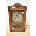 An early 20th century oak cased mantel clock, having carved decorations, brass spandrels to dial,