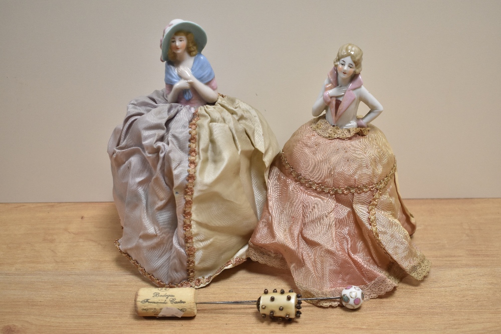 Two continental figural pin cushions, hat pins, and a box of spectacles