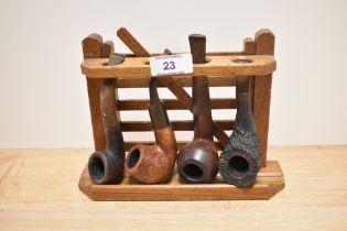 A vintage pipe rack in the form of a gate, sold with four pipes, including tug boat and Special R.