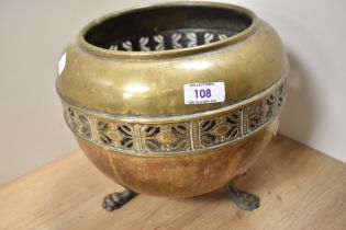 An Edwardian brass jardiniere, with a pierced band design and downswept animal feet, measuring